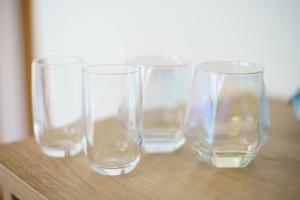 cuatro vasos vacíos sentados en una mesa de madera en BURan House, en Tokio