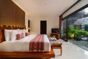 um quarto com uma cama grande e uma varanda em Adepa Resort em Canggu