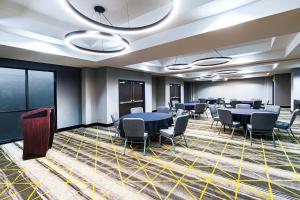 a meeting room with tables and chairs in a room at Holiday Inn Hotel & Suites Tulsa South, an IHG Hotel in Tulsa