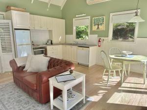 Apollo Bay的住宿－Apple Tree Cottage，一间带棕色沙发的客厅和一间厨房