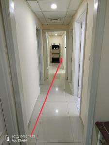 un largo pasillo con una línea roja en el suelo en Master room 1, Couples should be married, en Abu Dabi