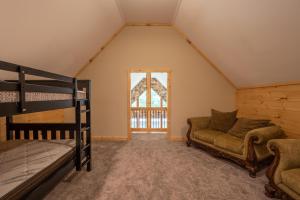 een slaapkamer met een stapelbed en een bank bij The Mountain Lodge in Elliottsburg