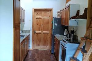 cocina con puerta de madera y fogones en Casa Alegre II- Hush Valley Lodge, en Río Blanco