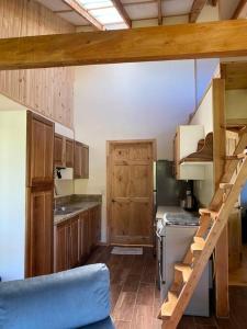 una cocina con armarios de madera y una escalera. en Casa Alegre II- Hush Valley Lodge, en Río Blanco