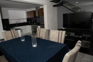 uma mesa de jantar com uma toalha de mesa azul e cadeiras em Casa en puebla em El Gallinero