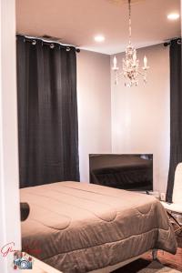a bedroom with a bed with black curtains and a chandelier at Parkton Place An Outdoor Venue in Hope Mills