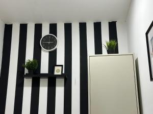 a black and white striped wall with a clock and a mirror at Solo Partition Room in Al Barsha 1 Near Mashreq Metro in Dubai