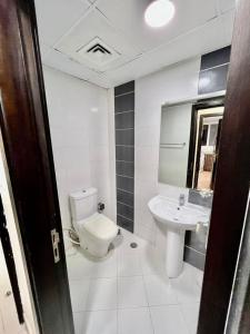 a white bathroom with a toilet and a sink at Solo Partition Room in Al Barsha 1 Near Mashreq Metro in Dubai