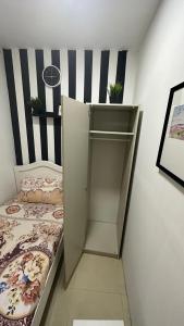a small bedroom with a bed and a shelf at Solo Partition Room in Al Barsha 1 Near Mashreq Metro in Dubai