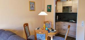 eine Küche mit einem Tisch und Stühlen sowie ein Esszimmer in der Unterkunft FeWo Nordsee Whg. 11 in Sankt Peter-Ording