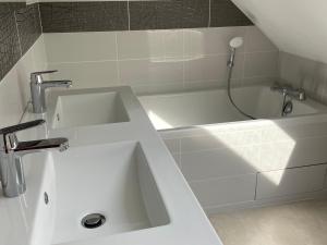 a white bathroom with a sink and a bath tub at Maison spacieuse près du Mans et Tours, idéale pour famille, avec terrasse, jardin et parking - FR-1-410-425 in Chahaignes +19 photos