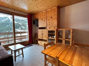 a living room with a wooden table and wooden cabinets at Appartement Méribel, 2 pièces, 4 personnes - FR-1-355-122 in Méribel