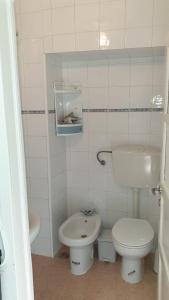 La salle de bains blanche est pourvue de toilettes et d'un lavabo. dans l'établissement Central Lisbon Sao Jorge 2 bedroom private apartment, à Lisbonne