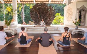 un grupo de personas sentadas en una clase de yoga en Anima Retreat Bali, en Krambitan