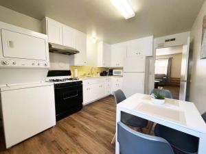 una cocina con electrodomésticos blancos y una mesa con sillas. en 434-Campbell Cozy & Bright 2B/1b /AC/close to Downtown, en Campbell