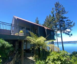 a house with a view of the water at The Nest - Relax & Unwind with Breathtaking Views over Lake Taupo in Taupo