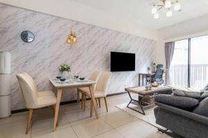 台北2B1bLK, Stylish & Comfortable, 5 Min to Ximen MRT • 2房1衛 客廳廚房 時尚舒適 5分到西門站的带桌子和电视的客厅