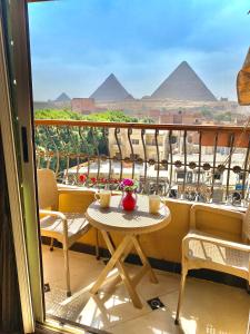 un tavolo su un balcone con vista sulle piramidi di Ramses Pyramids View Apartment a Il Cairo