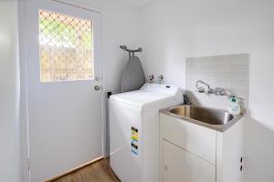 a small kitchen with a sink and a refrigerator at Growder Court 3 - Coolum Beach QLD in Coolum Beach