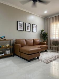 a living room with a brown couch and a window at Seaview apartment in Kuala Terengganu