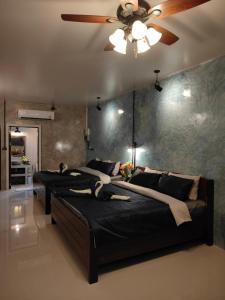 Smilingface guesthouse في سوخوثاي: غرفة نوم بسريرين ومروحة سقف