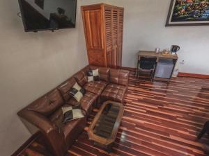 salon z brązową skórzaną kanapą i stołem w obiekcie Gran Kunturwasi Hotel Senior w mieście Cajamarca