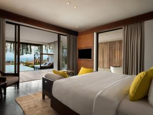 a bedroom with a large bed and a living room at Six Senses Uluwatu in Uluwatu