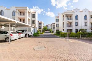 Un estacionamiento con autos estacionados frente a los edificios. en Budget-Friendly & Cozy Haven by BK Hospitable, en Midrand