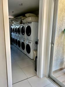 a laundry room with a row of washers and dryers at Los laureles towers in Asunción