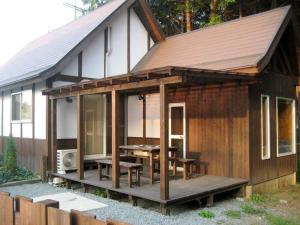 a cabin with a table and chairs on a deck at 天然温泉！古民家風の貸切り一軒家 【白山リバーサイドコテージ 】2-120号棟 in Nihongi