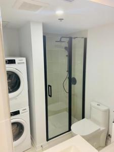 a bathroom with a toilet and a washing machine at Appartement condo avec terrasse privée dans le Quartier des Spectacles in Montréal