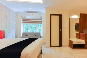 a hotel room with a bed and a window at Collection O 65916 Companion Leisure Homes in Kovalam