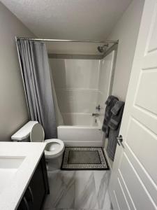 a bathroom with a toilet and a shower and a sink at The Waterfront cozy 1 bd suite in Rockland Park, Tuscany NW in Calgary