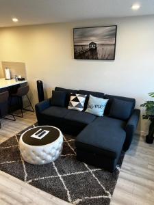 uma sala de estar com um sofá e uma mesa em The Waterfront cozy 1 bd suite in Rockland Park, Tuscany NW em Calgary