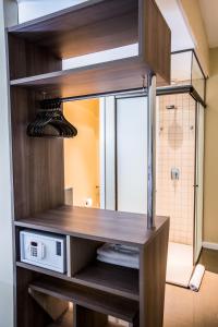 クイアバにあるSlim Cuiabá Aeroportoの木製の棚に電子レンジが置かれたバスルーム +29枚の写真