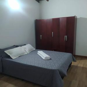 a bedroom with a bed with a wooden cabinet at Hermoso apartamento en Medellín in Medellín
