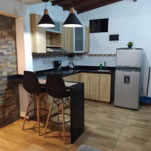 a kitchen with a refrigerator and two bar stools at Hermoso apartamento en Medellín in Medellín