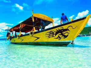 a yellow boat with a dragon painted on it in the water at Green Ocean Lodge in Koh Rong Island
