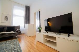 sala de estar con TV de pantalla plana grande en Modern Apartment near City Center 1BR en Viena