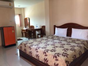 1 dormitorio con 1 cama y 1 mesa con sillas en Ratchaphruek Resort en Lop Buri
