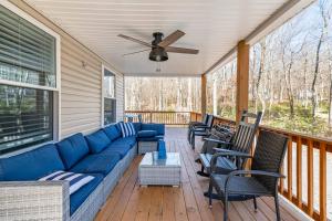 Sofá azul en un porche con sillas y ventilador de techo en Parkwood Manor at Bear Creek Lakes in Jim Thorpe, en Jim Thorpe