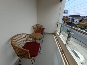a row of chairs sitting on top of a balcony at The Cabin Hotel Sumberan in Yogyakarta