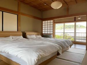 a bedroom with a large bed in a room with windows at Kungin Bettei - Vacation STAY 14605 in Himeji