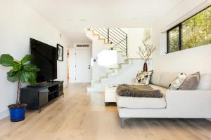 uma sala de estar com um sofá branco e uma televisão em Exceptional Hilltop View Villa em São Francisco