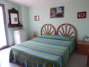 ヴィッラ・サン・ピエトロにあるCasa vacanza Corneliaのベッドルーム1室(カラフルなストライプ毛布付きのベッド1台付)
