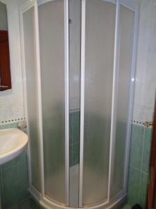 a shower in a bathroom with a sink at Apartamentos San Pelayo in Cangas de On&iacute;s