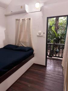 a small room with a bed and a window at Beer's House Bungalows เบียร์เฮ้าส์บังกะโล in Ban Lamai