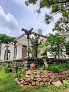 a house with a cross on top of a stone wall at Heritage Home, Hampe's in Mysore