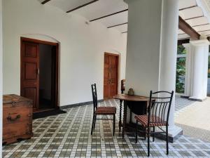 une chambre avec deux chaises et une table dans un bâtiment dans l'établissement Heritage Home, Hampe's, à Mysore