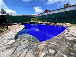una piscina de agua azul en un patio en Group house with views of the salt pool and spa en Mitcham